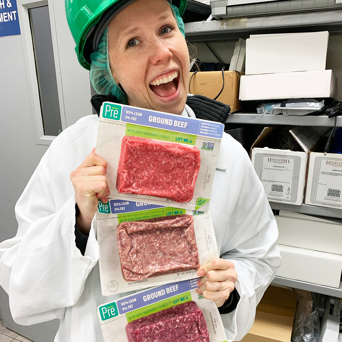 Julie, the food scientist and quality manager at Pre brands, holidng different beef packages that have different shades of pink and brown meat in them.