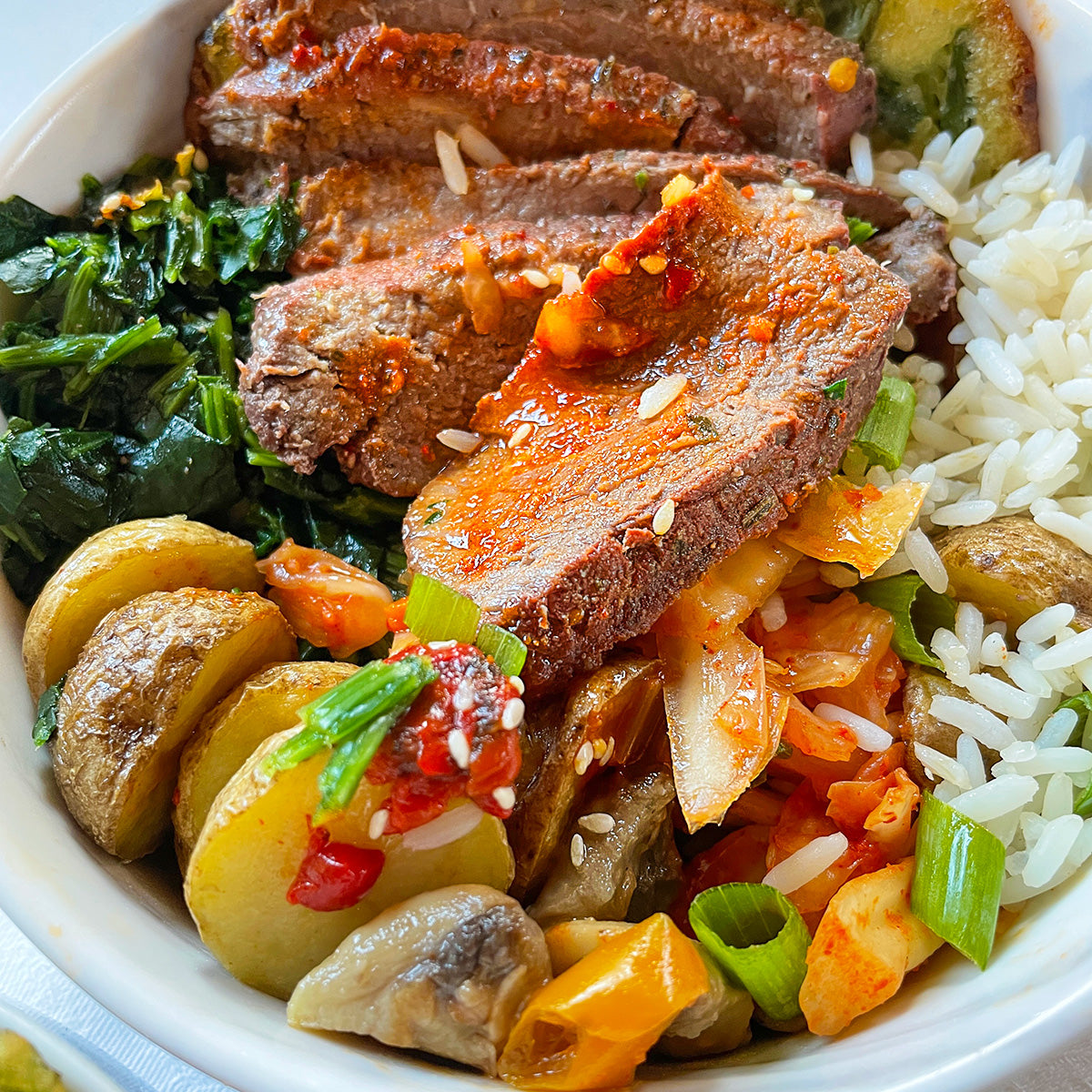 Sirloin steak bowl with mushrooms and potatoes and spinach and rice