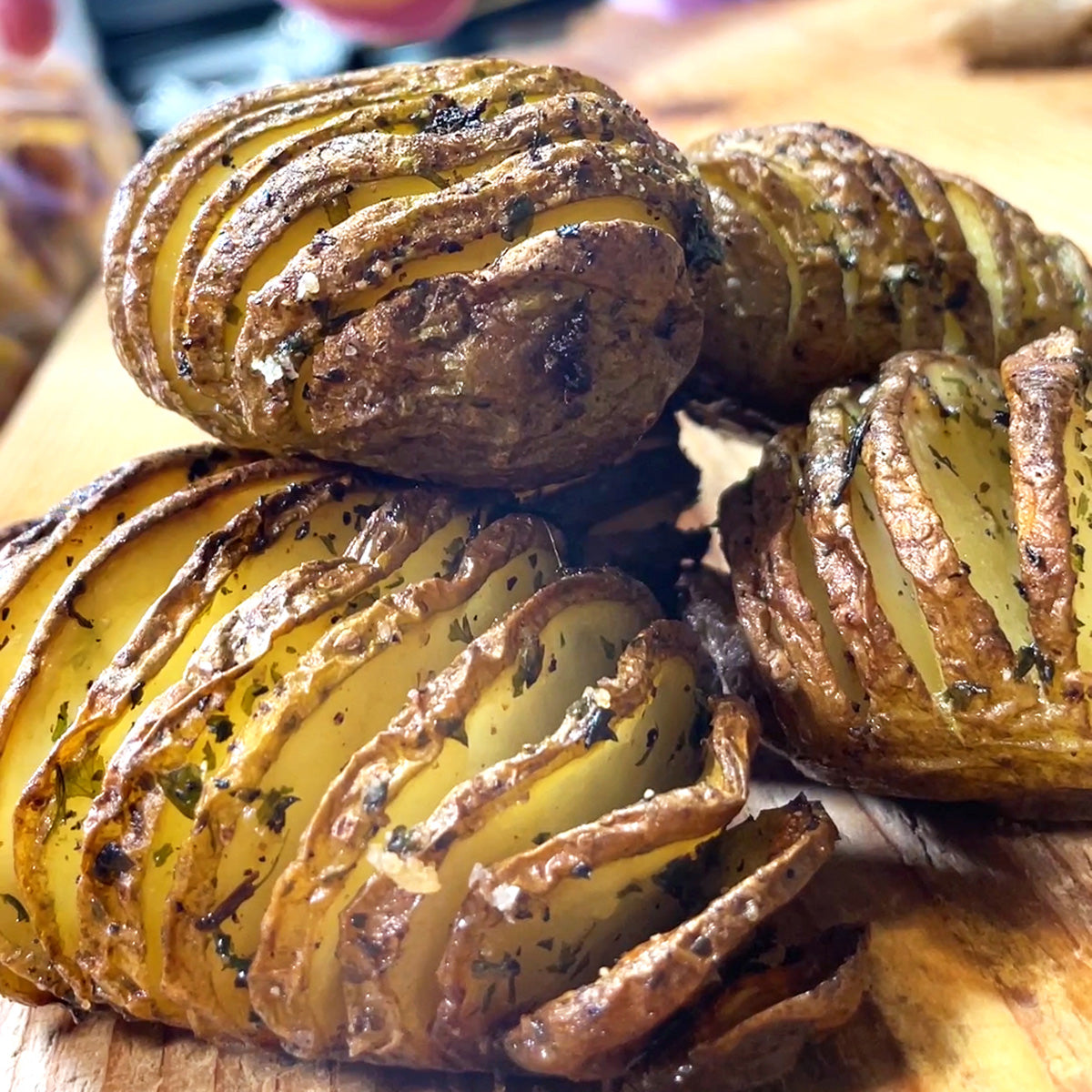 A bunch of potatoes that have sliced across them like an accordian and herbs and butter