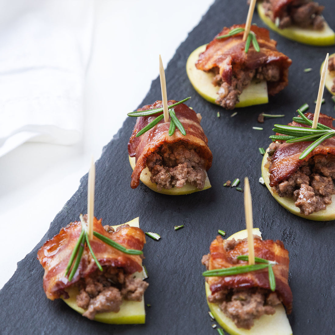 Rosemary ground beef with bacon nibbles on a black slate