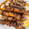 A plate of skewers with ginger garlic drizzled around it