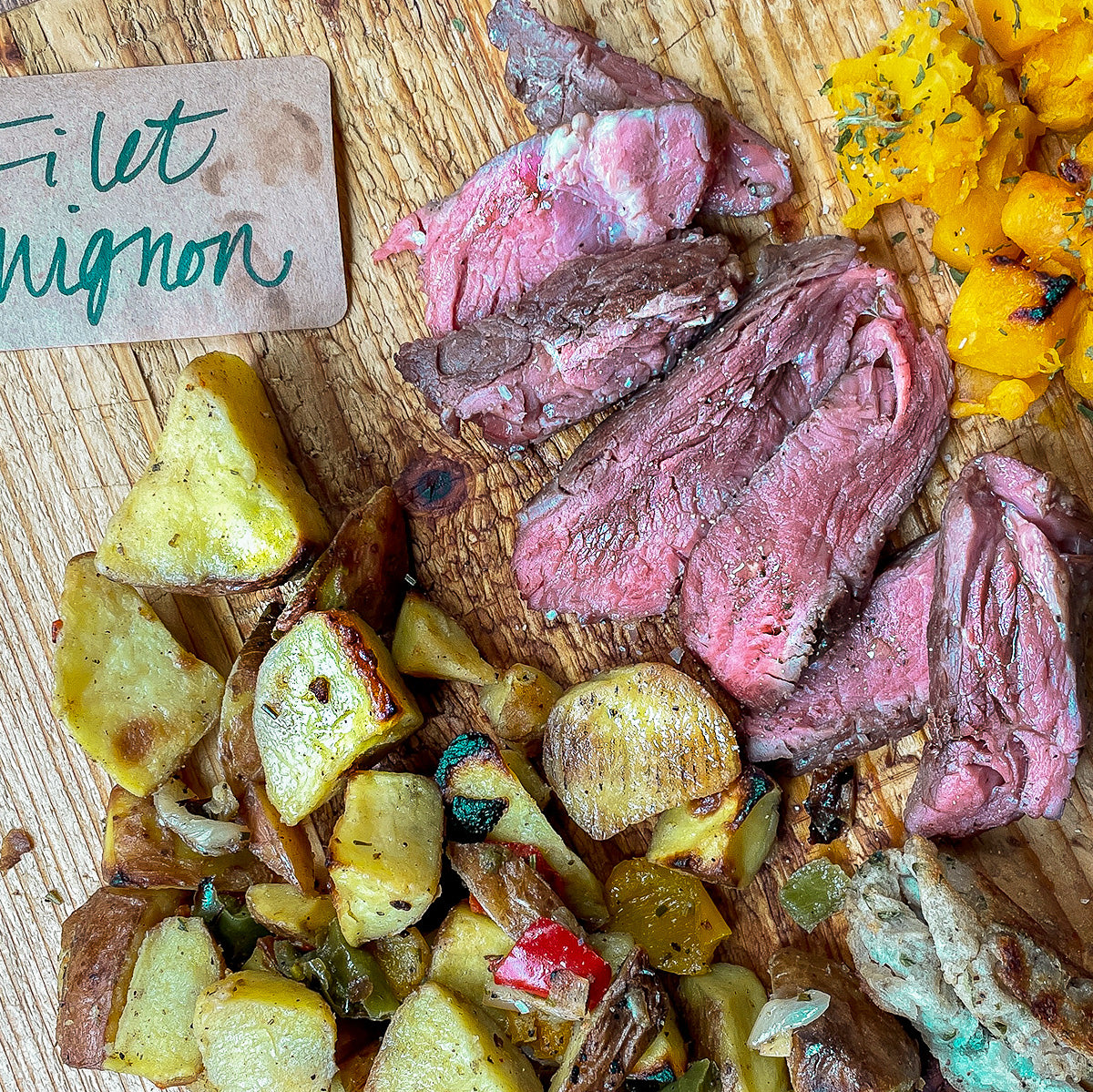 A board with roasted potatoes and steak